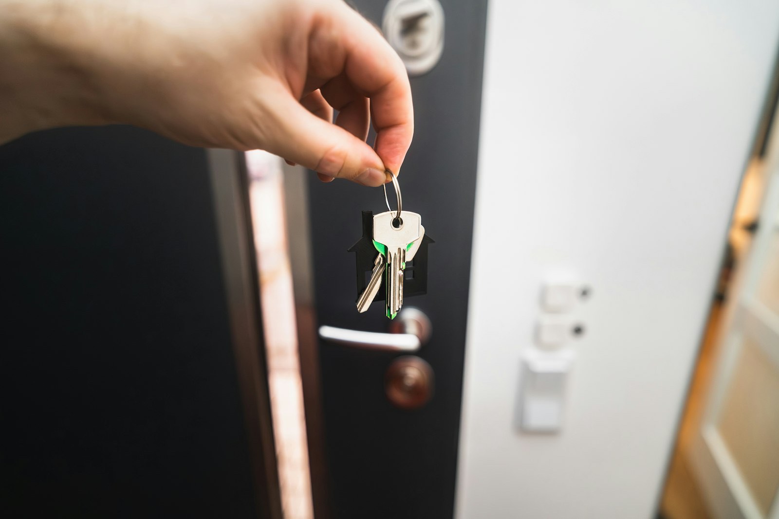Hand holding house keys at a front door
